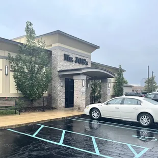 a white car parked in front of a restaurant