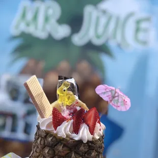 a pineapple topped with ice cream and strawberries