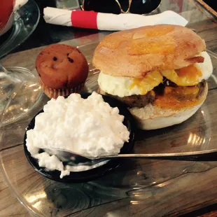 Breakfast bagel with cottage cheese side and muffin.