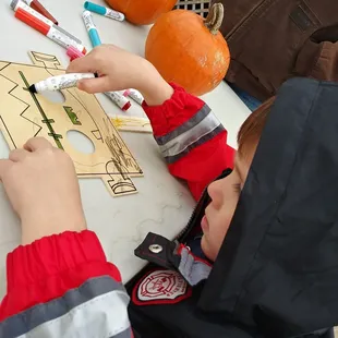 a young boy cutting out a pumpkin