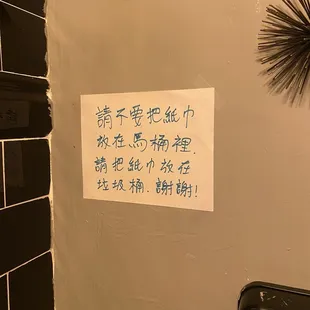 Signs says put papers in trash, not toilet.
