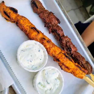 two skewers of food on a tray