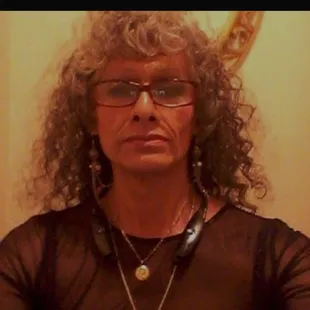 a man with curly hair and glasses