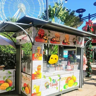 a food stand with a ferris wheel in the background