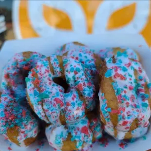 a plate of donuts with sprinkles