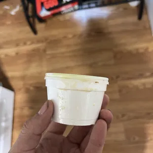 a hand holding a container of yogurt