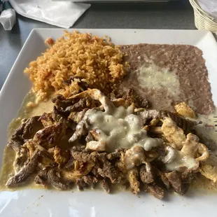 Mr. Bandido (chicken and steak smothered in queso with rice and refried beans)