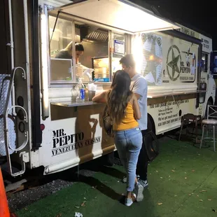 two people ordering food from a food truck