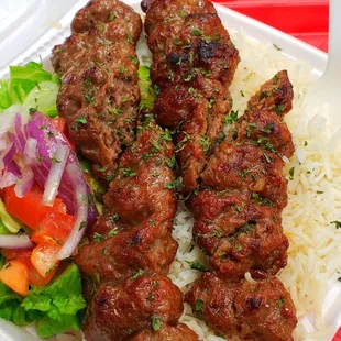 Beef kebobs with rice and salad plate.  Good flavors