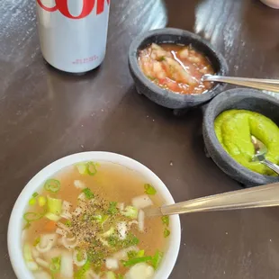 a bowl of soup and a can of coke