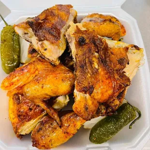 a styrofoam container of chicken wings and pickles