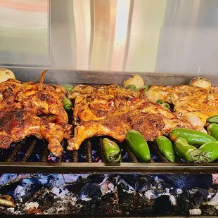 chicken and peppers cooking on a grill