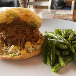 a pulled pork sandwich and green beans