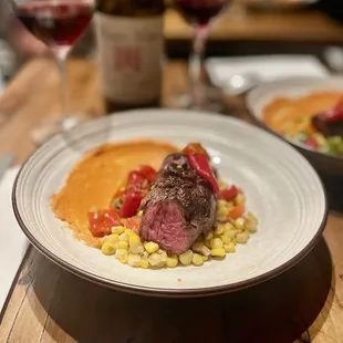 Hangars steak with romesco sauce, roasted corn, various pickled peppers, and cherry tomato