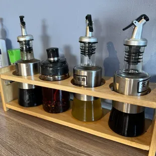 Variety of condiments including black vinegar, red pepper oil, soy sauce, and green Sichuan pepper oil.