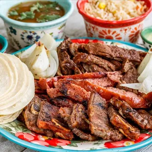 Mixed plate: ribs, sausage, beef, rice, beans, tortillas, grilled onion, lime &amp; salsa