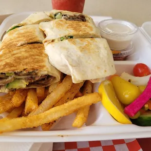 Beef shawarma sandwich with fries, pickled veggies, and sauces