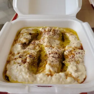 Close-up of baba ganoush (pita bread is in the brown bag behind it)