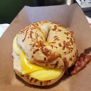Breakfast sandwich with bacon on Asiago cheese bagel.