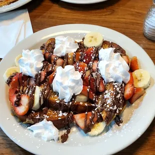 French toast with bananas, strawberries, and whipped cream  with Nutella. Very delicious