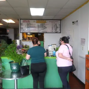 two women standing at a counter in a restaurant