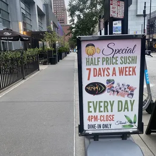 a sign for a special half price sushi 7 days a week every day