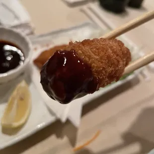 a close up of a fried donut on a stick