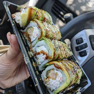 a person holding a tray of sushi