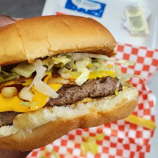 a hand holding a hamburger