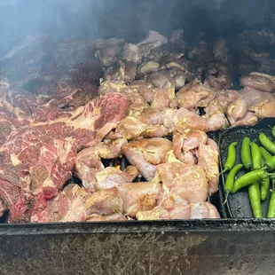 meat and vegetables cooking on a grill