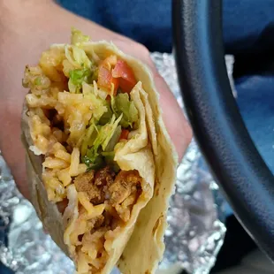 a hand holding a burrito