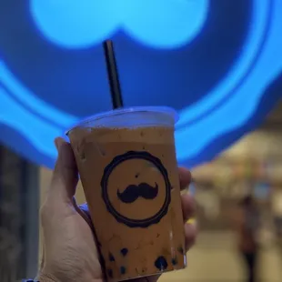 a hand holding a cup of iced coffee