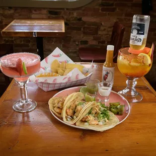 Shrimp tacos, chips, strawberry margarita, and a beer mangoneada