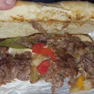 a beef sandwich with peppers and onions