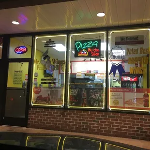 the front of a restaurant with neon signs