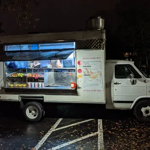 Outside the food truck. Passenger side. Ordering window and self-serve shelves.