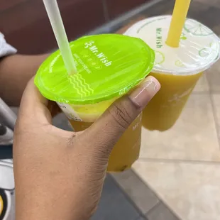 a person holding a plastic cup with a straw