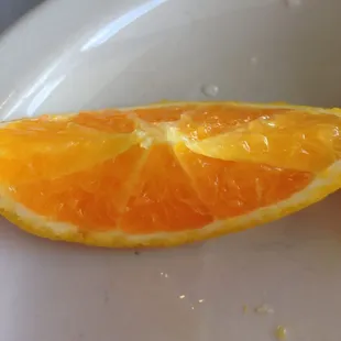 a half of an orange on a plate