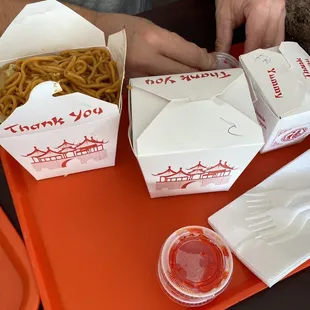 a table with two boxes of noodles and a cup of ketchup