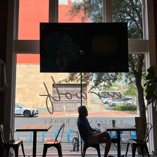 a man sitting in a chair in front of a window