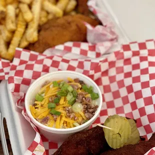 a basket of fried chicken and a bowl of pickles