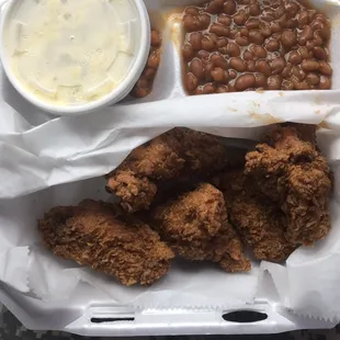 Chicken wing dinner with baked beans and potato salad
