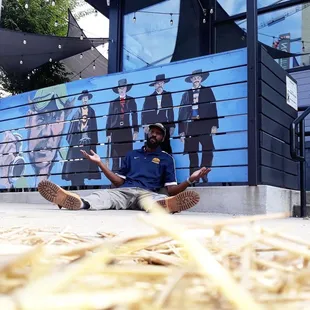 a man sitting in front of a mural