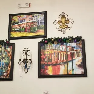 a man sitting at a table in front of paintings