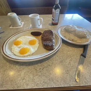 New York strip steak, sunny, side up eggs and a half plate of biscuits and gravy.