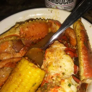 a plate of crab, corn and potatoes