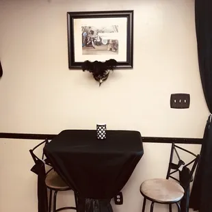 a table with a black tablecloth and two stools