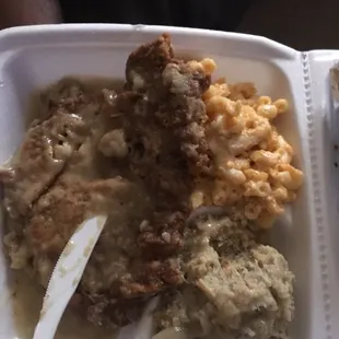 Fried pork chop with gravy , dressing , and mac and cheese