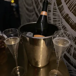 two champagne glasses and a bottle of champagne