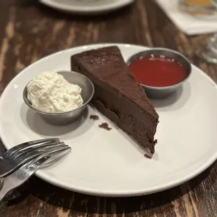 Flourless chocolate cake with whipped cream and strawberry sauce